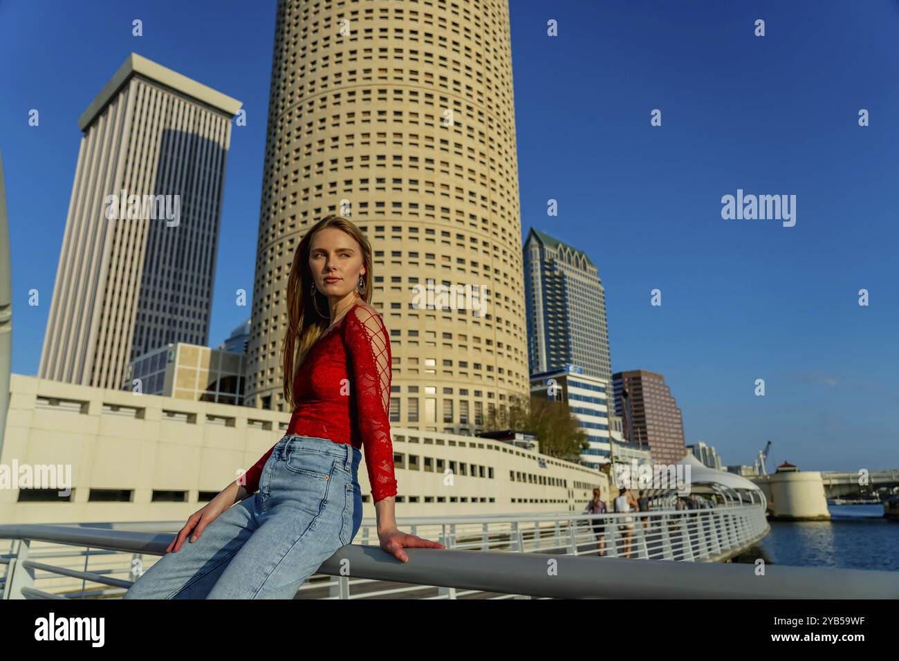 Un bellissimo modello biondo gode del bel tempo in una grande città Foto Stock