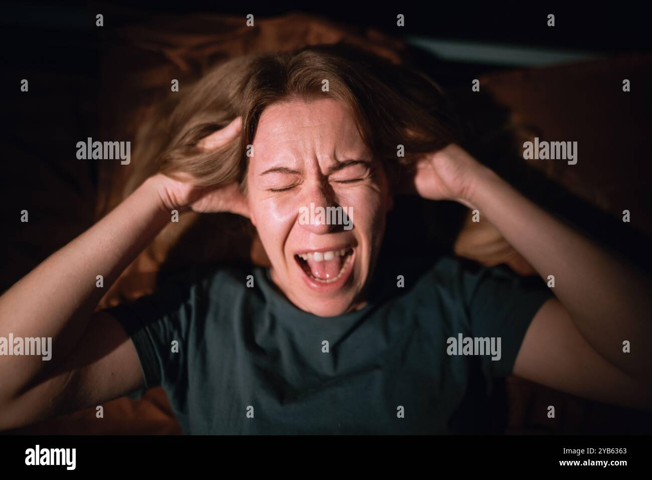 vista dall'alto donna di notte che ha ansia e urla mentre ha incubi, disturbi del sonno e attacchi di panico. Foto Stock