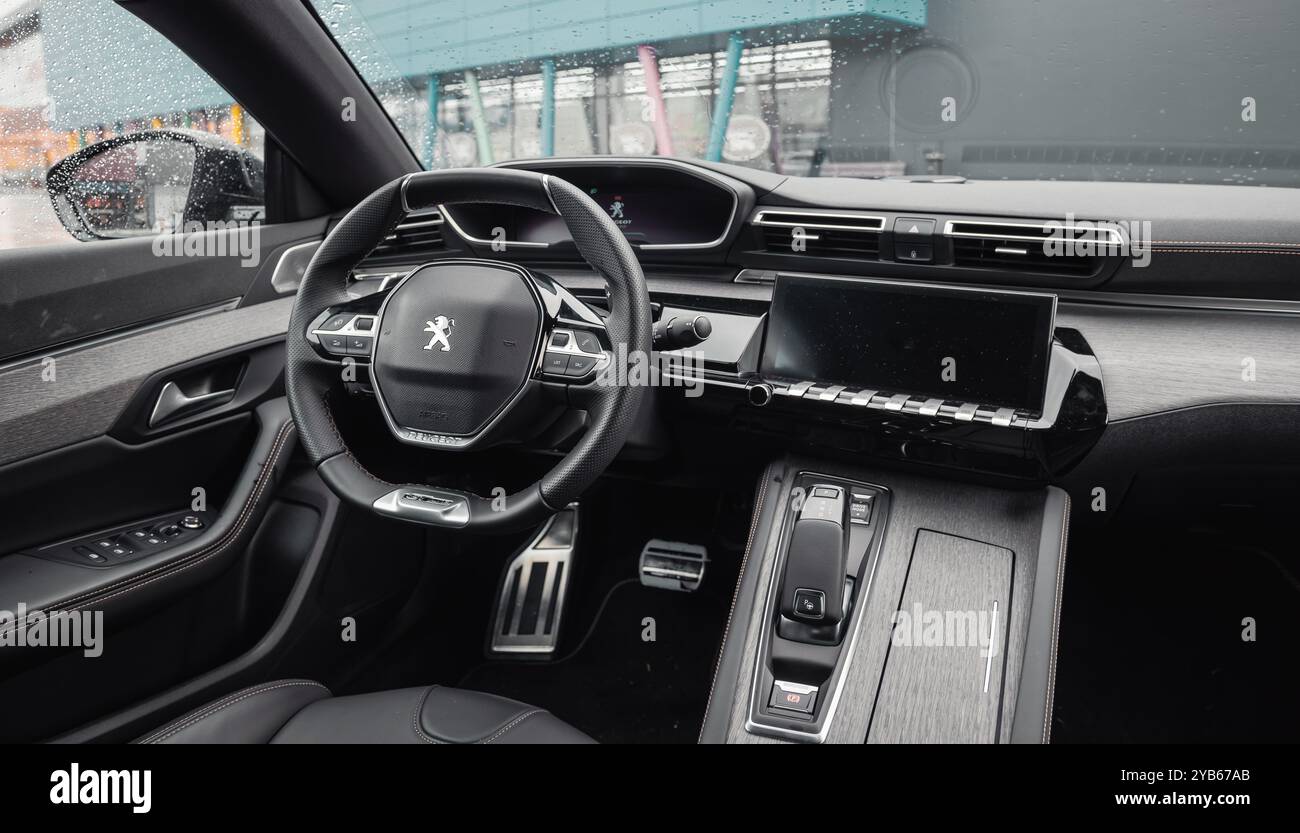 Interno grigio scuro di Peugeot 508. Pannello anteriore, cruscotto, volante e console centrale dell'elegante berlina Peugeot. Foto Stock