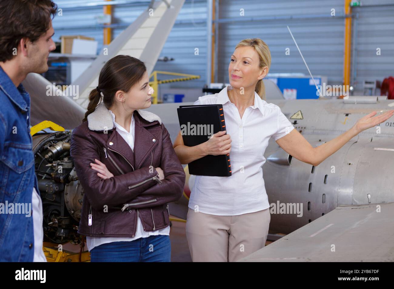 donna matura che fa il giro dell'hangar degli aerei Foto Stock