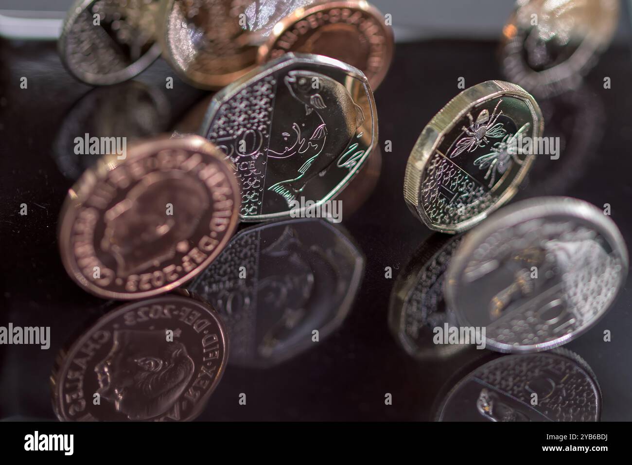 Sterling Coins, sua altezza reale Re Carlo III, in piedi su un top nero riflettente Foto Stock