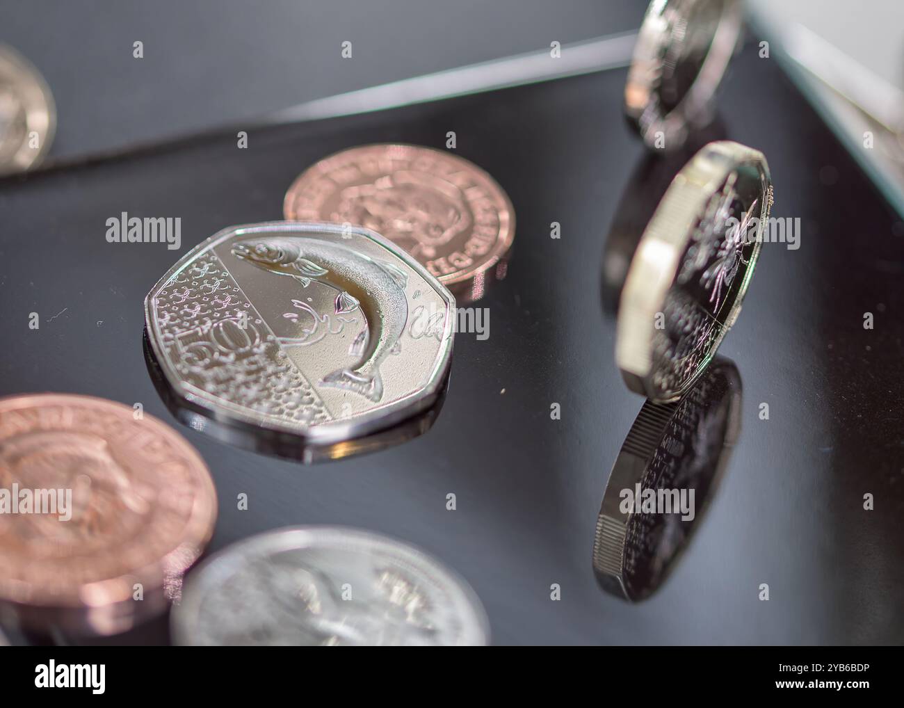 Sterling Coins, sua altezza reale Re Carlo III, in piedi e adagiati su una parte superiore nera riflettente Foto Stock