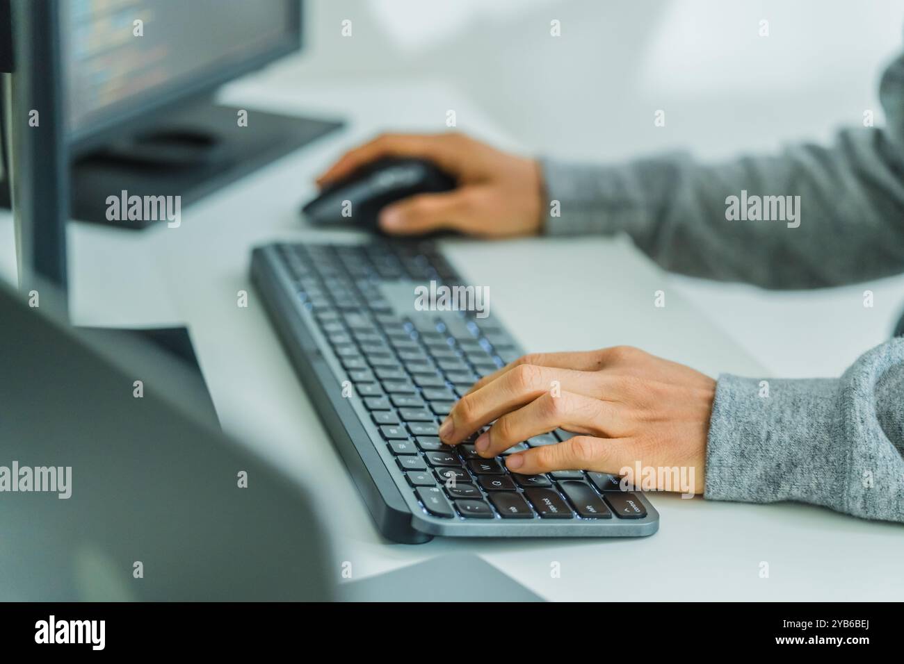 primo piano: programmazione manuale dello sviluppatore con tastiera sulla scrivania di un ufficio moderno Foto Stock