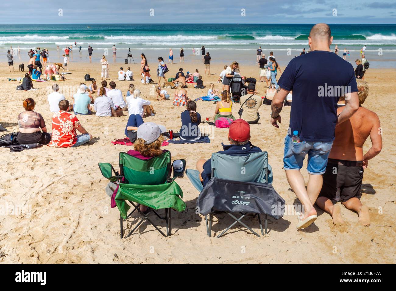Turisti che si godono il sole estivo sull'iconica spiaggia Fistral di Newquay, in Cornovaglia, nel Regno Unito. Foto Stock