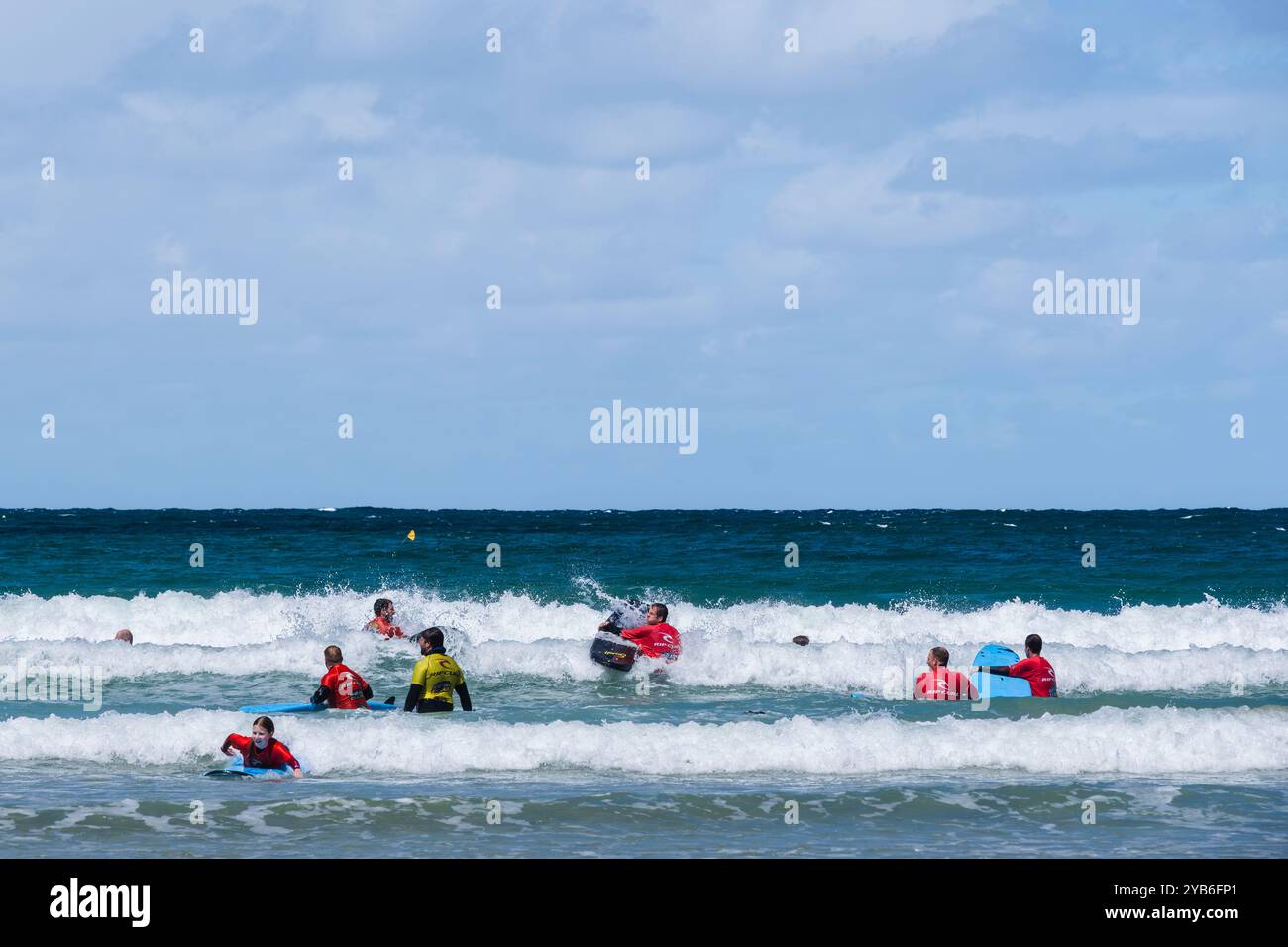 Principianti di surf che tengono una lezione di surf con un istruttore del NQY Activity Centre presso Towan Beach a Newquay in Cornovaglia nel Regno Unito. Foto Stock