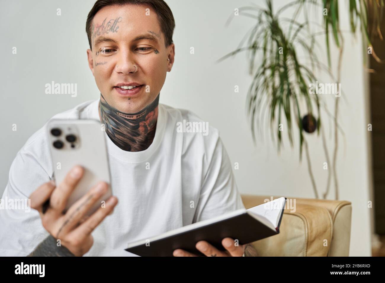 Un giovane ama trascorrere un momento a casa mentre interagisce con il suo smartphone, sorridendo e rilassandosi. Foto Stock