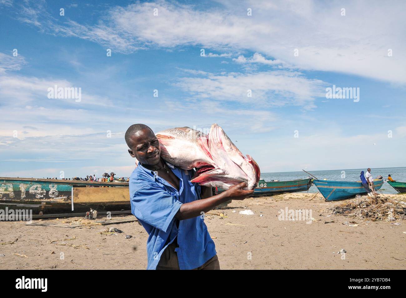 Un pescatore con il suo pescato a Kasensero, cittadina di pescatori sulle rive del lago Victoria - Uganda Foto Stock