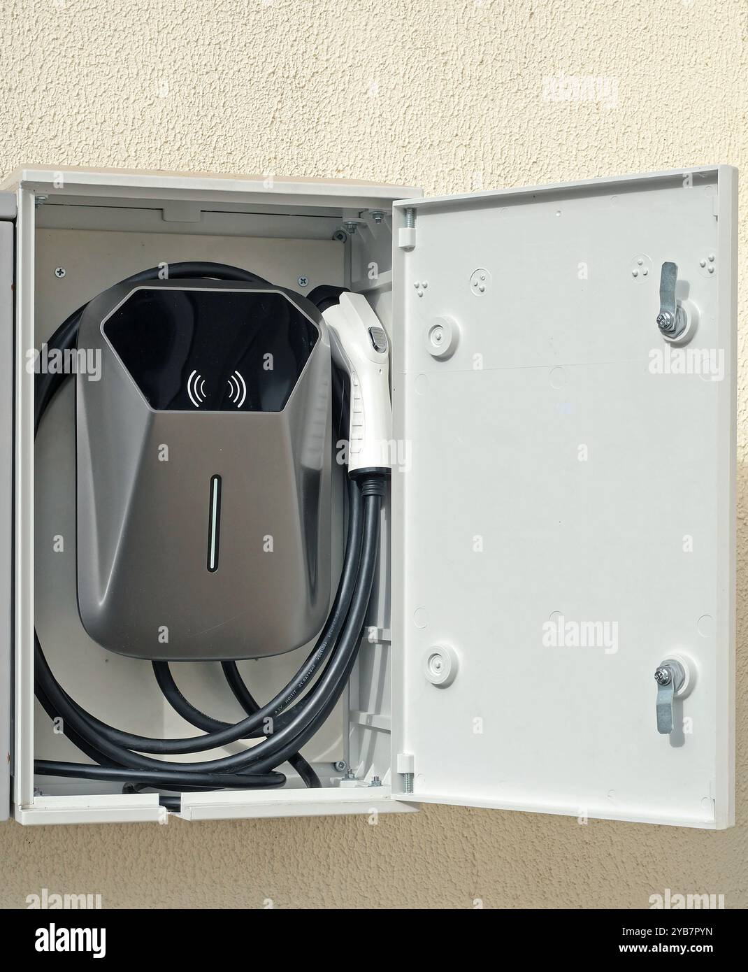 Stazione di ricarica per veicoli elettrici all'interno del cortile. Mini dispositivo a parete. Foto Stock
