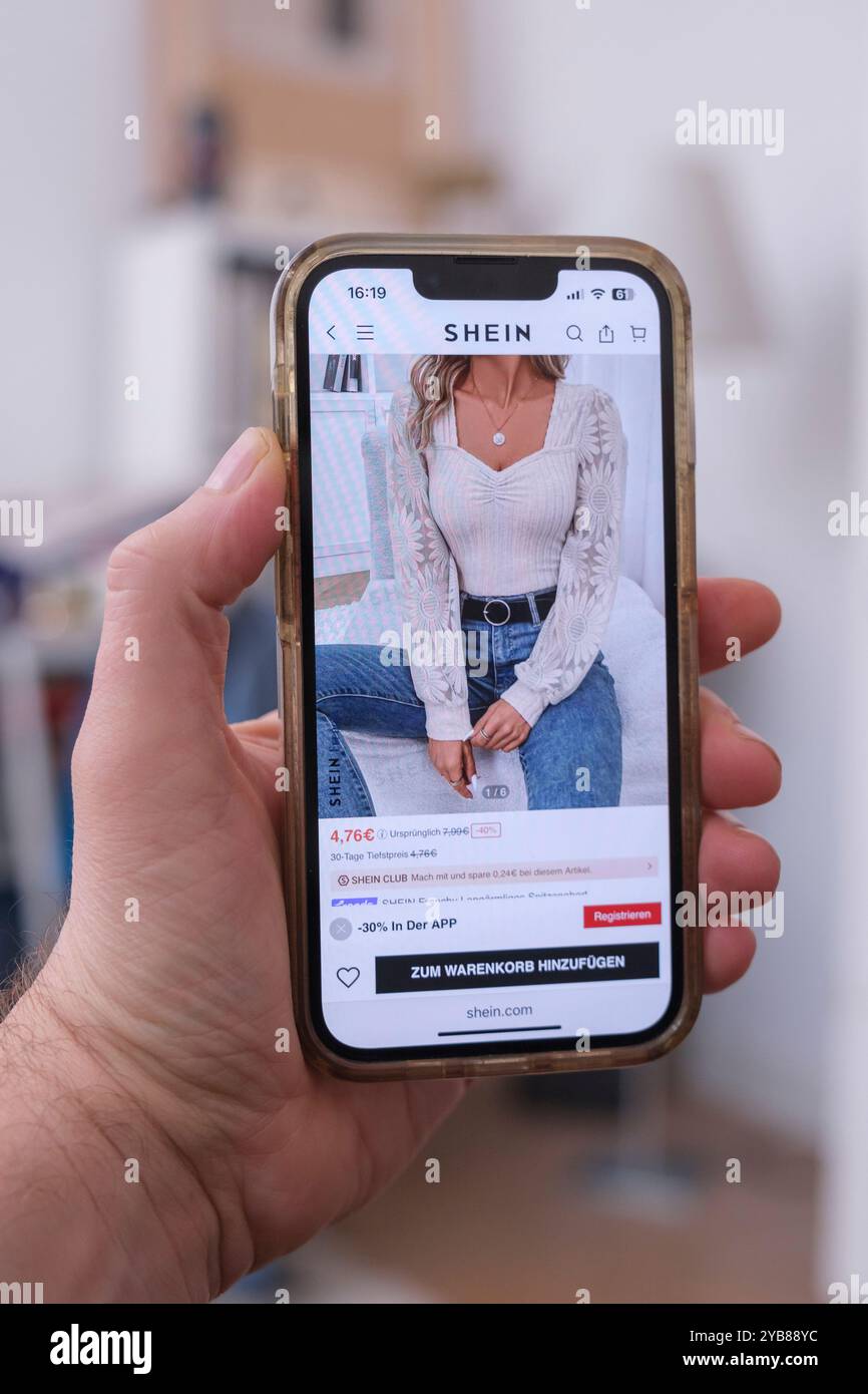 Mano che tiene un telefono cellulare che mostra il sito web della società cinese Shein Foto Stock