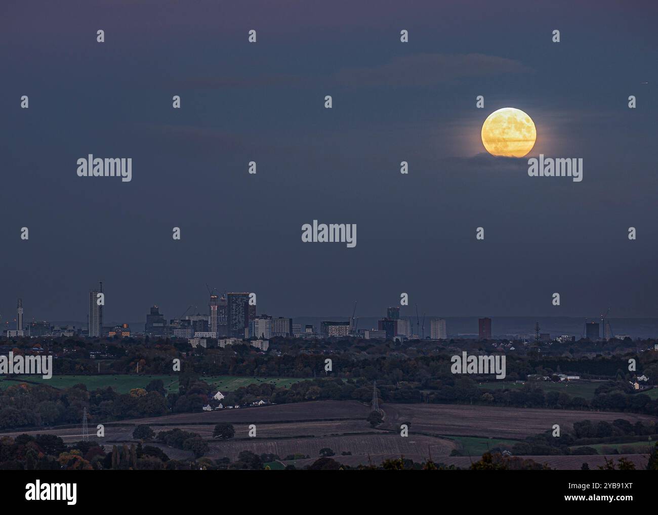 Birmingham, Regno Unito. 17 ottobre 2024. Meteo nel Regno Unito: La luna piena di questo mese finalmente sfonda le piccole quantità di nuvole basse sulla città di Birmingham. Questa è una luna di Harvest e l'ultima superluna dell'anno. Crediti: Lee Hudson/Alamy Live News Foto Stock