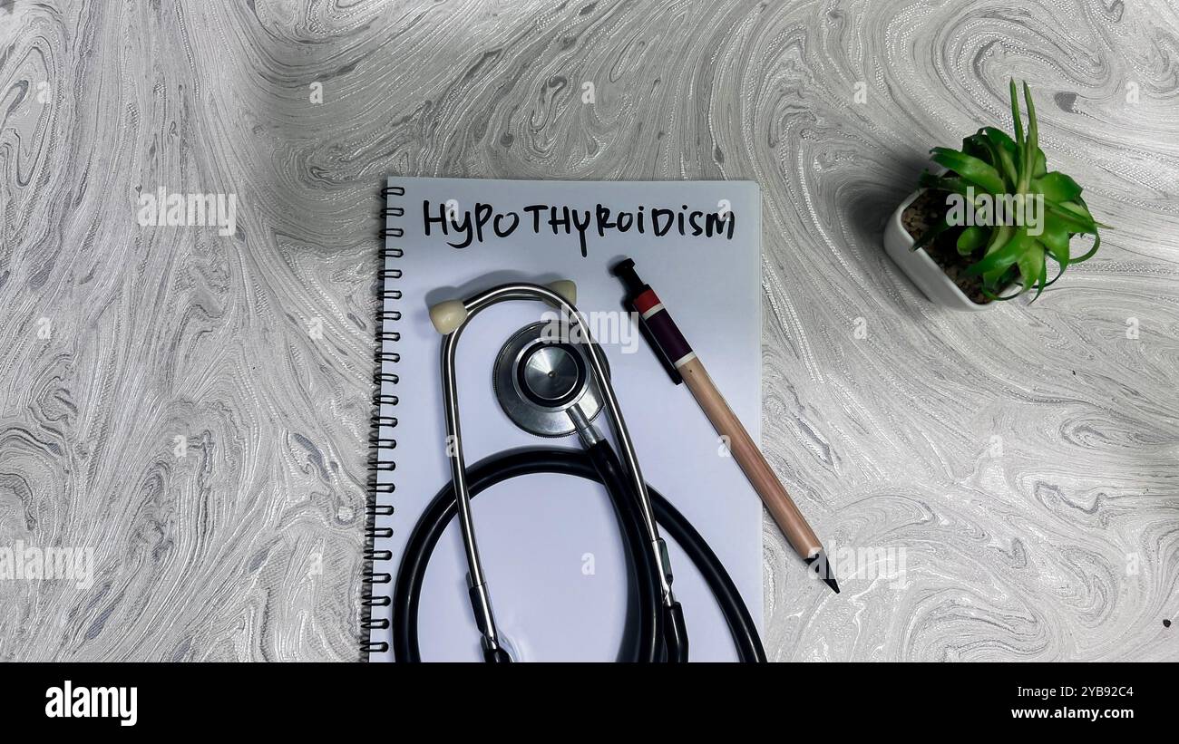 Concetto di ipotiroidismo scrivere su libro isolato su tavolo di legno. Foto Stock