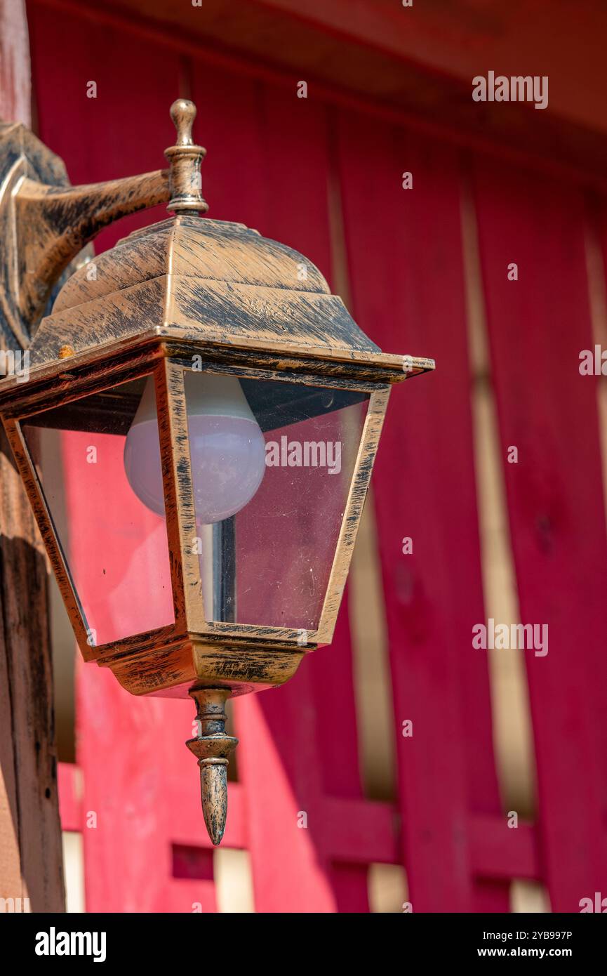 lampada o lanterna ruggine o corrosa in vecchio stile con lampadina moderna a risparmio energetico. Foto Stock