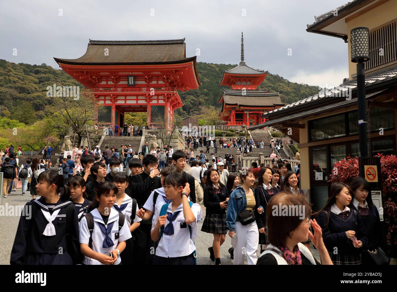 Vista dell'ingresso del tempio Kiyomizu-dera con un gruppo di studenti giapponesi in uniforme scolastica in primo piano. Kyoto, Giappone Foto Stock