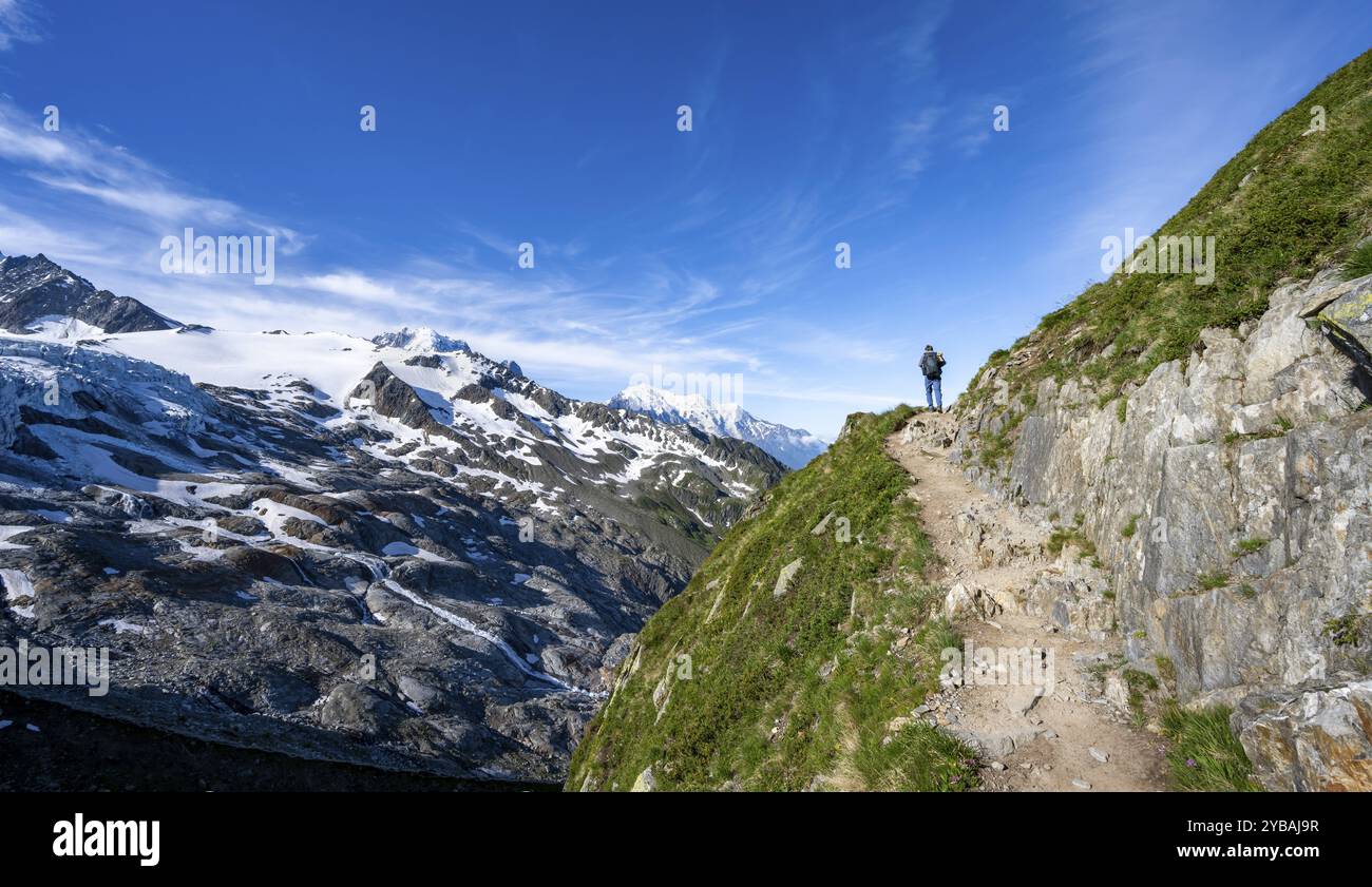 Alpinista su un sentiero escursionistico, vista del paesaggio di alta montagna alpina con ghiacciaio del Tour, ghiacciaio e cime montuose, Chamonix, alta Savoia Foto Stock