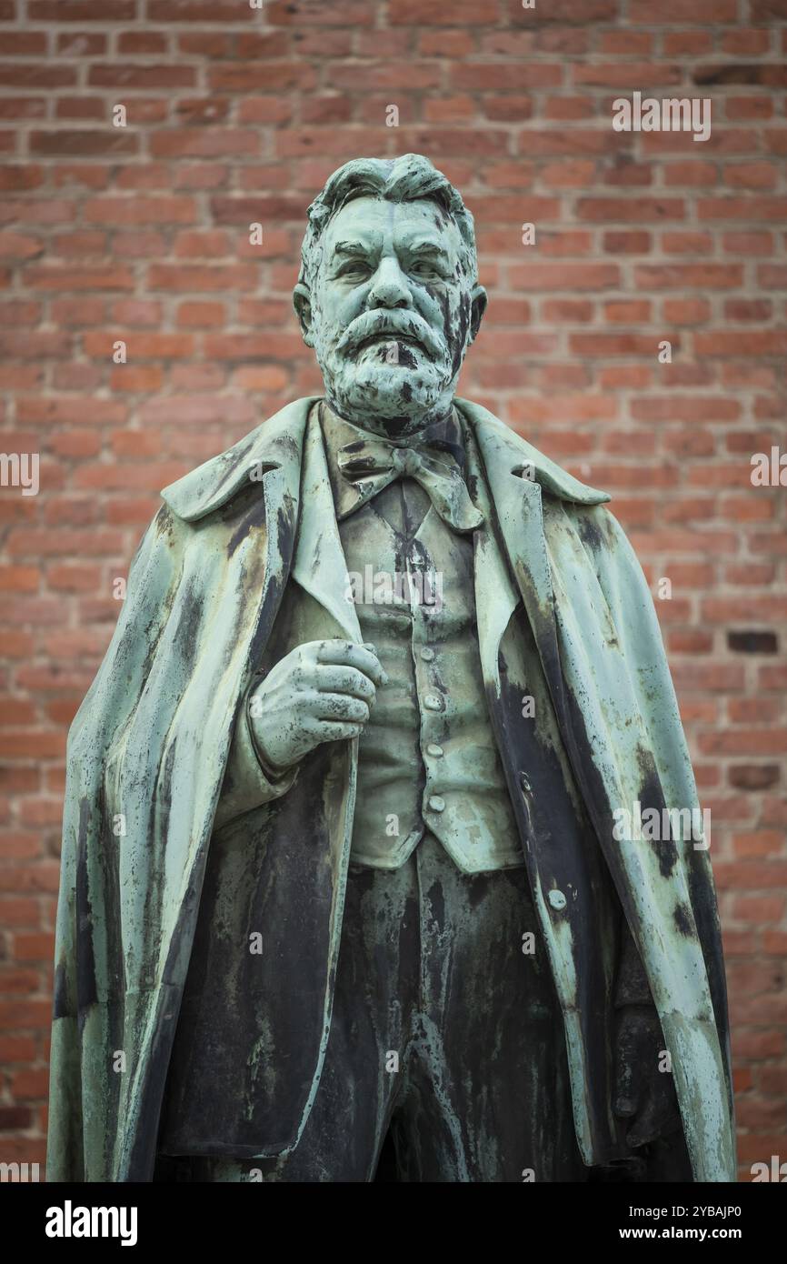 Statua in bronzo di Carl Jacobsen, imprenditore danese, collezionista d'arte e benefattore, di fronte al muro di mattoni, quartiere Carlsberg, Copenaghen, Den Foto Stock