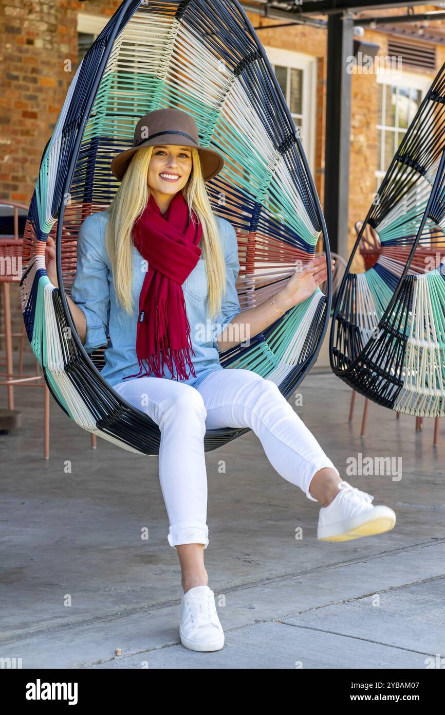 La bellezza bionda trasuda gioia con l'elegante abbigliamento autunnale, che irradia gli spiriti in una splendida giornata autunnale Foto Stock