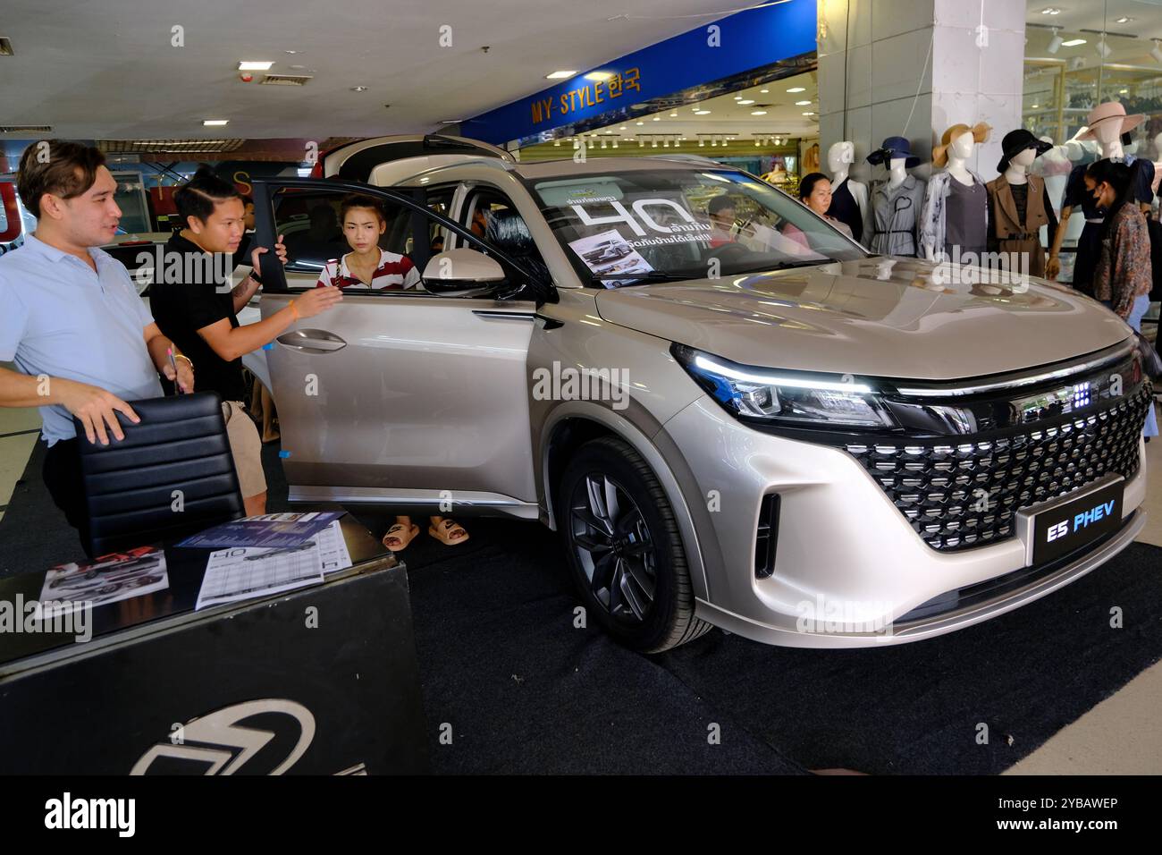 Un venditore di auto che mostra un SUV PHEV Dfsk Fengon E5 di fabbricazione cinese ai clienti all'ingresso del centro commerciale Talat Sao. Vientiane, Laos Foto Stock