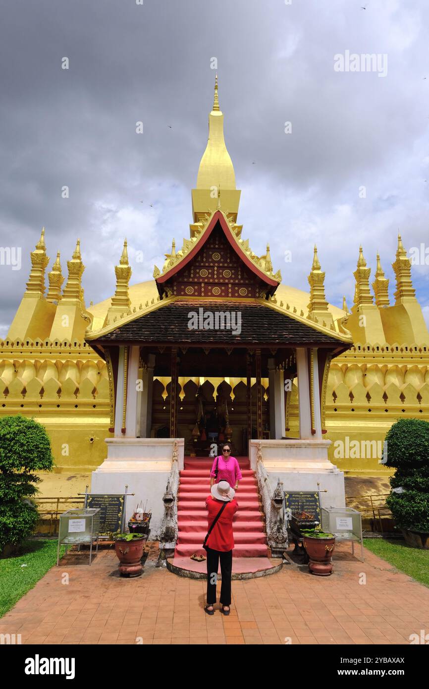 Turisti che scattano foto di fronte a Pha That Luang, "grande Stupa", il grande stupa buddhista ricoperto d'oro, simbolo del buddismo del Laos. Vientiane, Laos Foto Stock