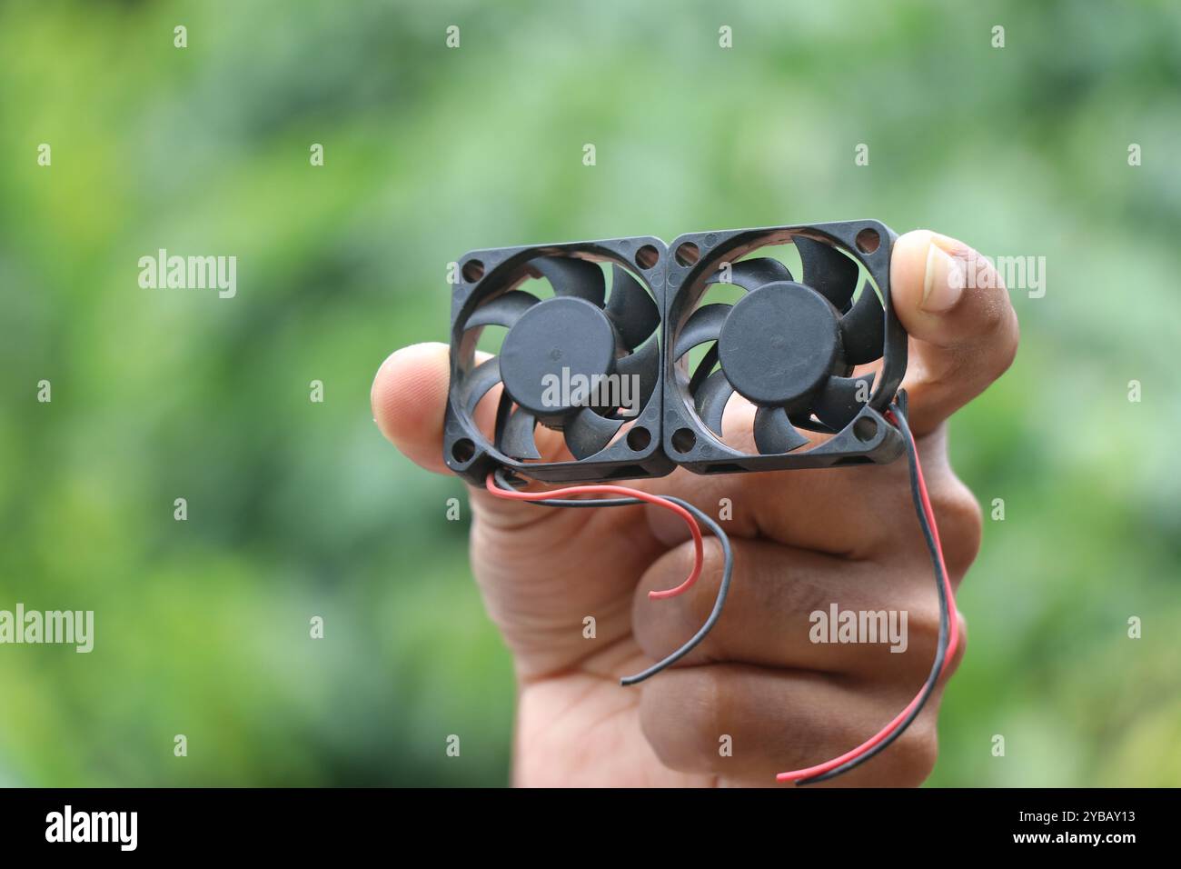 Ventola di raffreddamento utilizzata nel computer e in altri componenti elettronici per raffreddare i processori fornendo l'alimentazione d'aria tenuta in mano su sfondo naturale Foto Stock