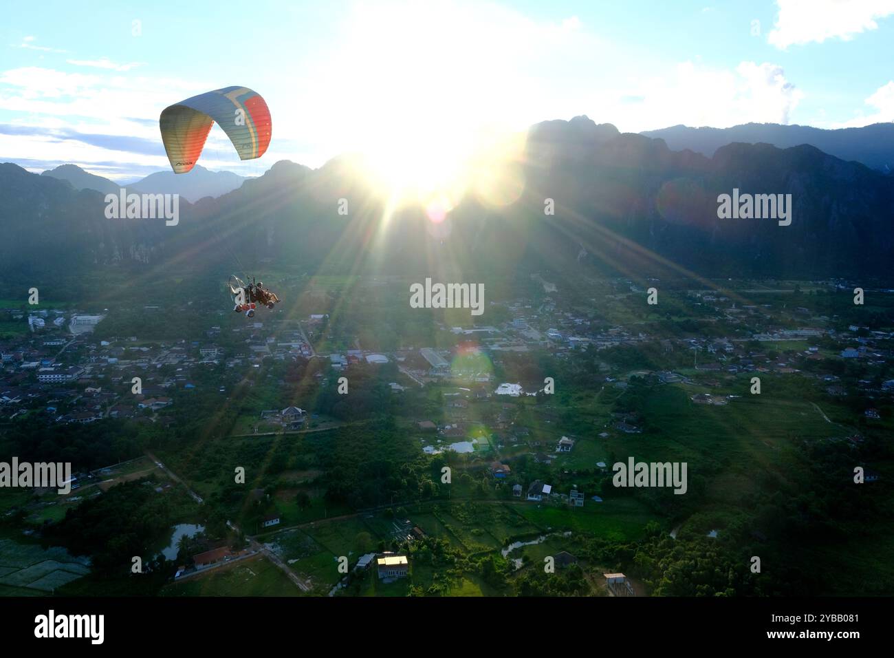 I paramotori trasportano turisti che volano sopra la città di Vang Vieng, Laos Foto Stock