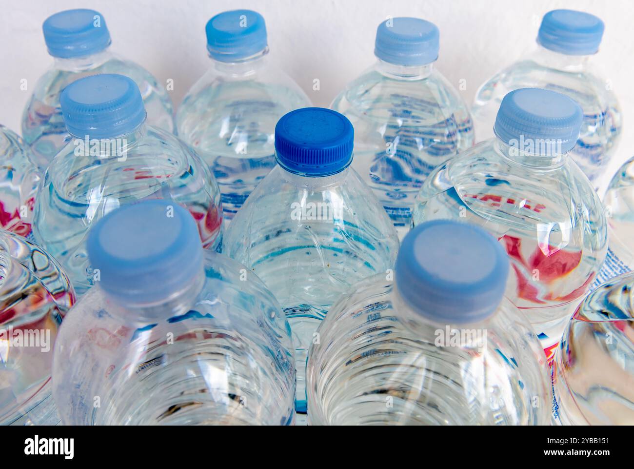 Primo piano di bottiglie d'acqua con una strana con tappo blu scuro. Foto Stock