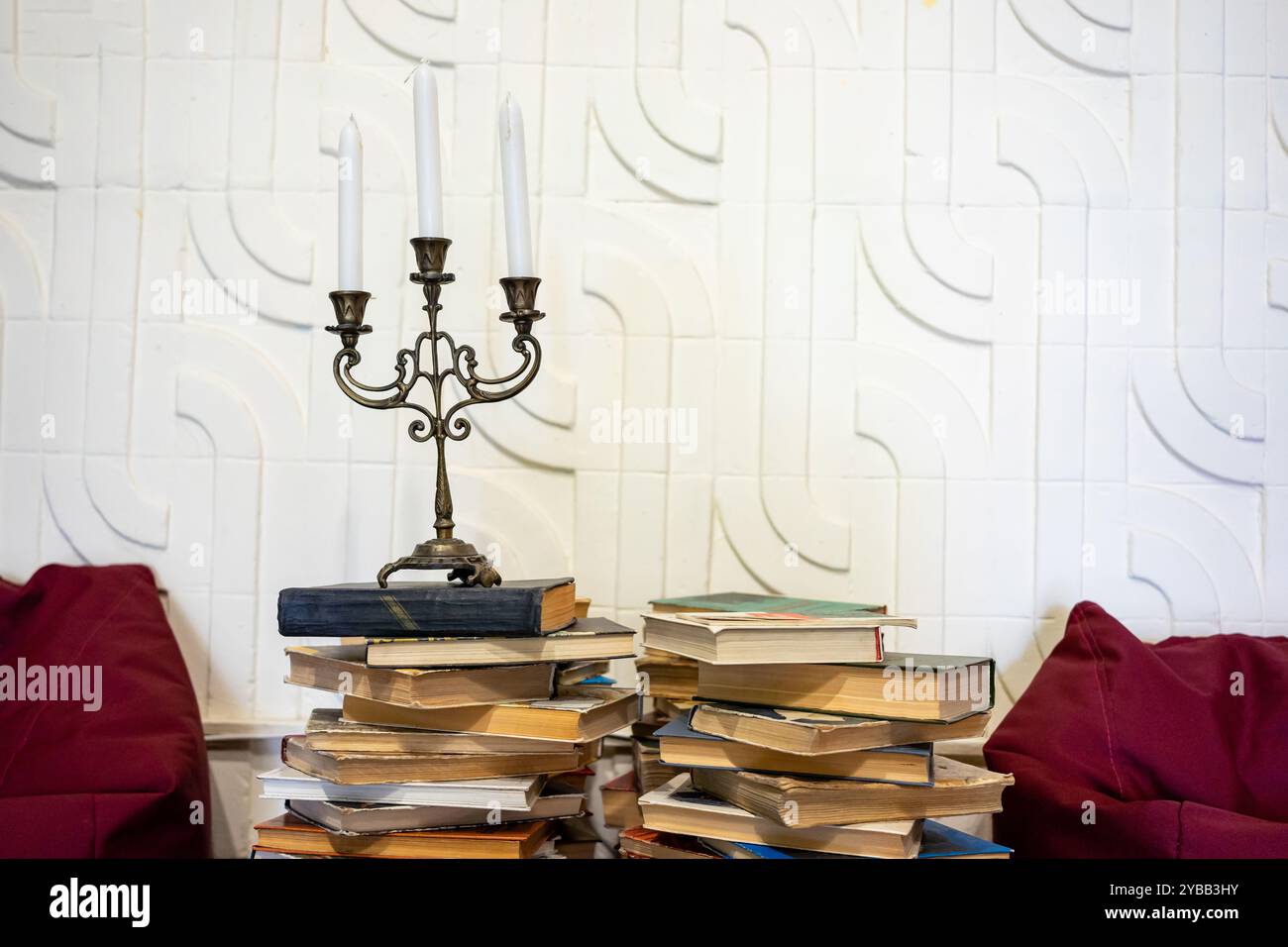 Antico candelabro e torre di libri come simbolo di storia e cultura. Foto Stock