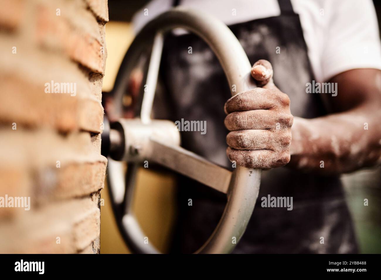 Mani, ruote e forno per fornaio, proprietario di una piccola impresa e laboratorio di pasticceria. Chef, fiducia e catering per bar, negozi e Foto Stock