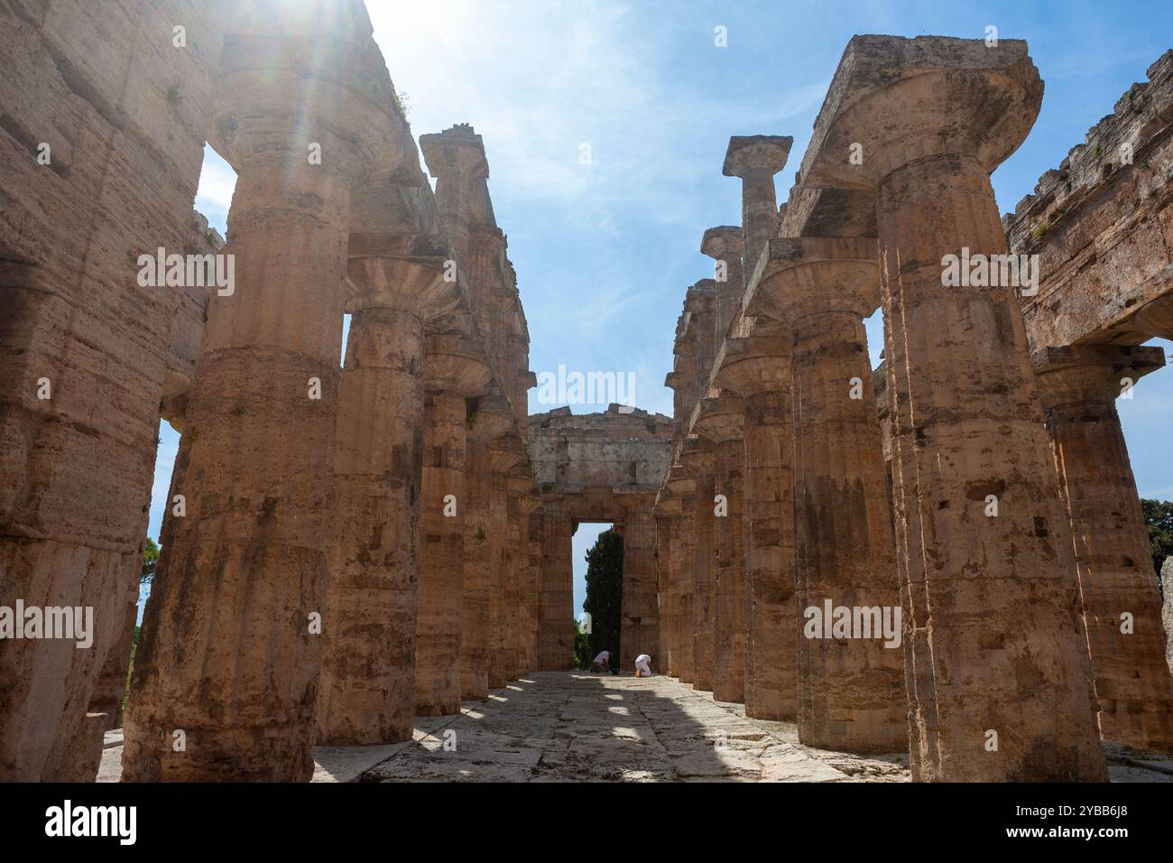 Due archeologi che lavorano nella cella o santuario interno del Tempio di era, uno dei templi greci meglio conservati al mondo: Paestum, Italia Foto Stock