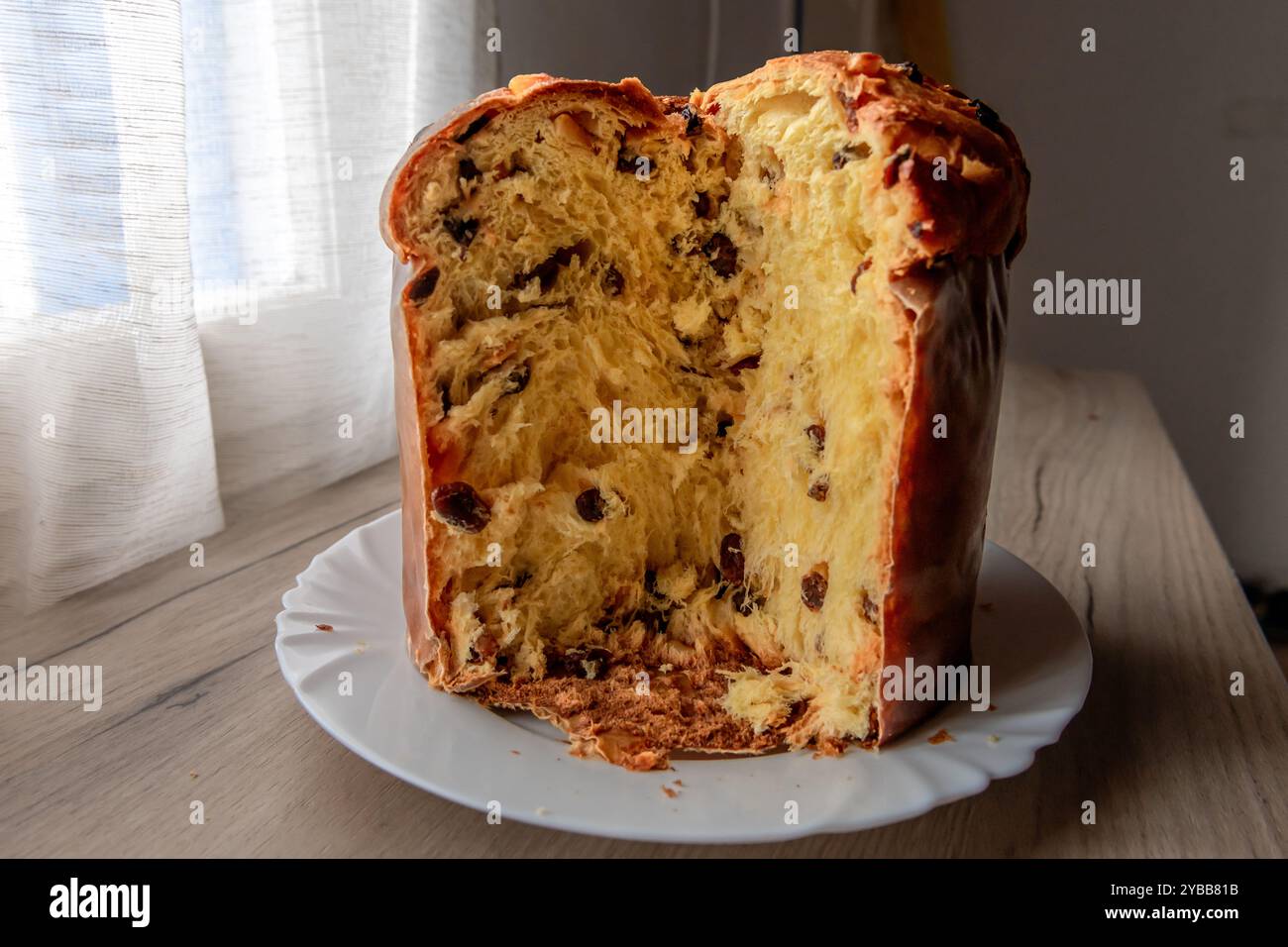 Panettone italiano, torta di Natale su una credenza, con una fetta di frutta e consistenza all'interno. Foto Stock