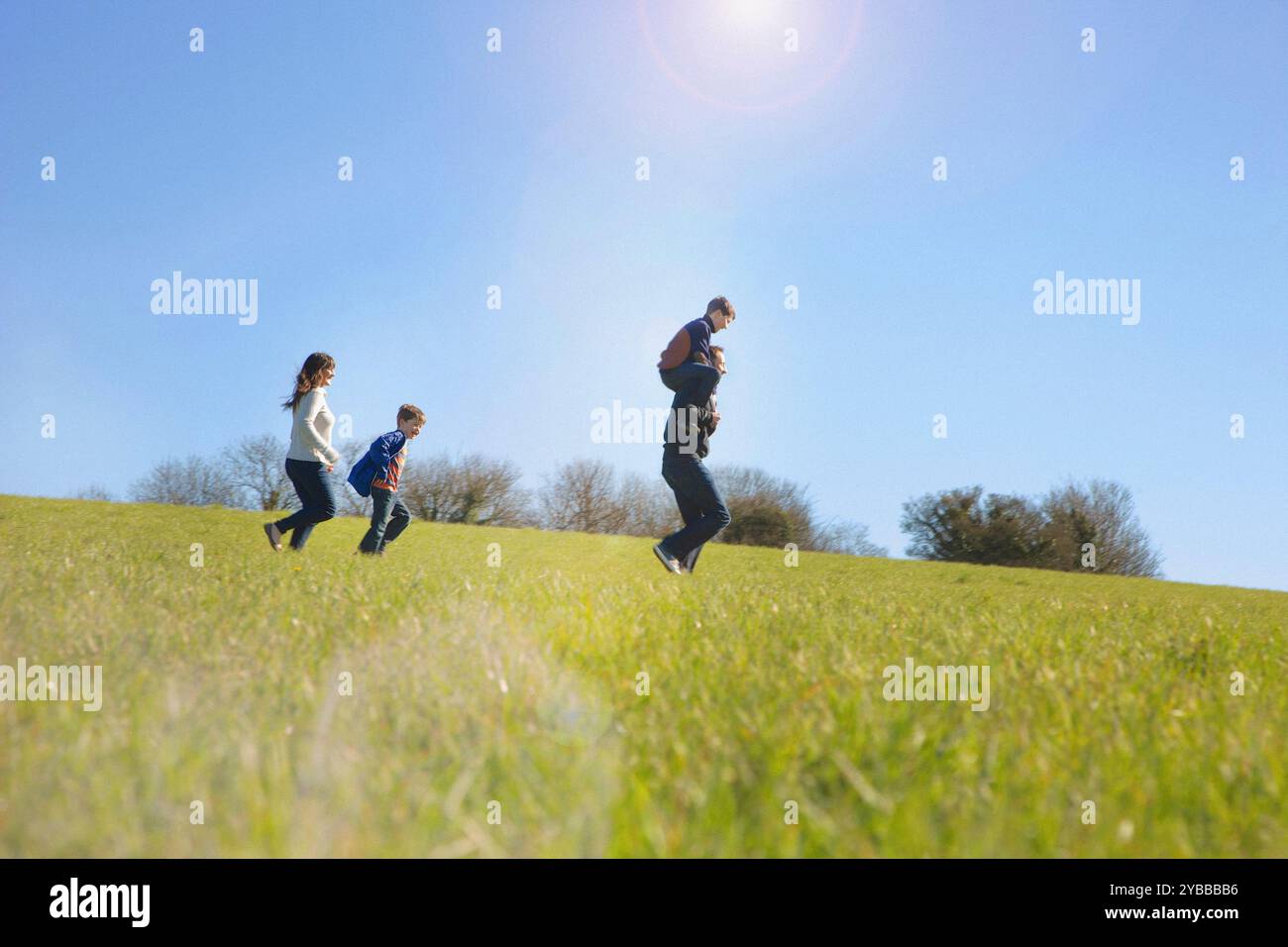 Famiglia in esecuzione sul campo Foto Stock