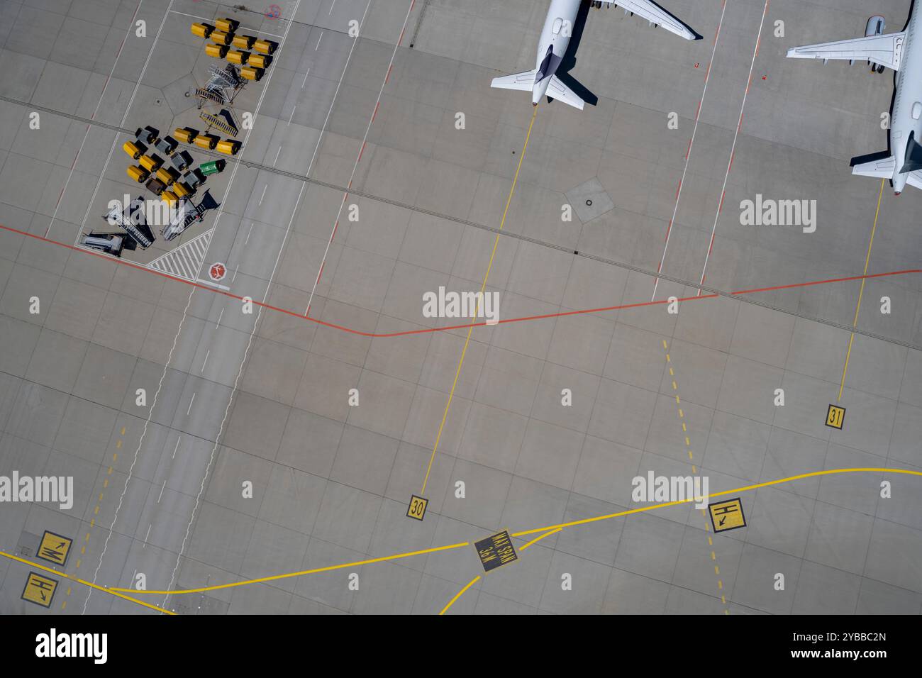 Vista dall'alto degli aerei e dei carrelli portabagagli sull'asfalto dell'aeroporto Foto Stock