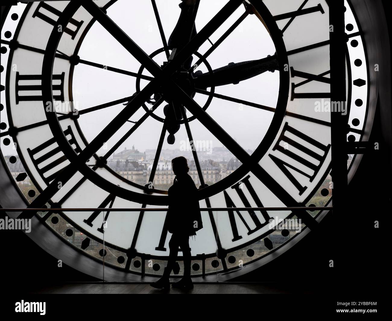 Una figura umana di silhouette si distingue contro un grande orologio del Musée d'Orsay di Parigi, Francia Foto Stock