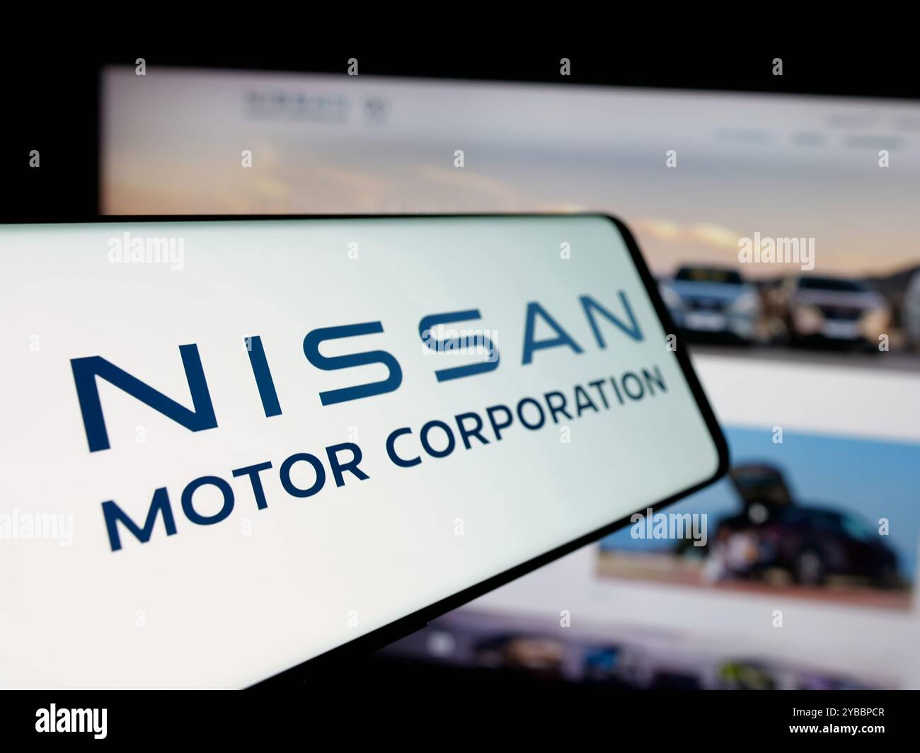 Cellulare con logo della società giapponese Nissan Motor Corporation sullo schermo di fronte al sito Web aziendale. Mettere a fuoco la parte sinistra del display del telefono. Foto Stock