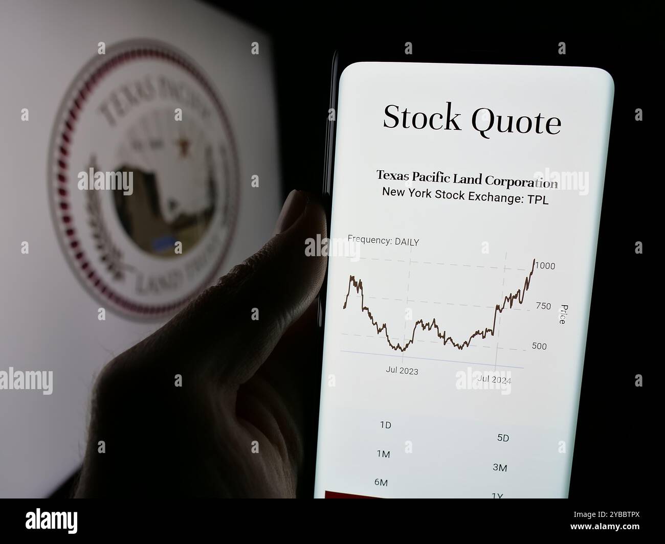 Persona che detiene un cellulare con la pagina Web della società statunitense Texas Pacific Land Corporation sullo schermo davanti al logo. Messa a fuoco al centro del display del telefono. Foto Stock