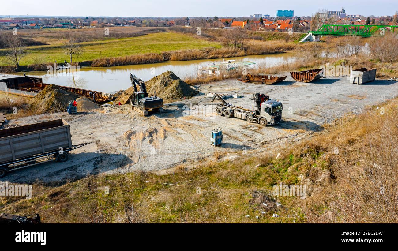 Sopra la vista dell'escavatore e del carro attrezzi, essi devono estrarre parte del letto, della chiatta, della costa fluviale, della cassazione, della nave di smantellamento, taglio r Foto Stock