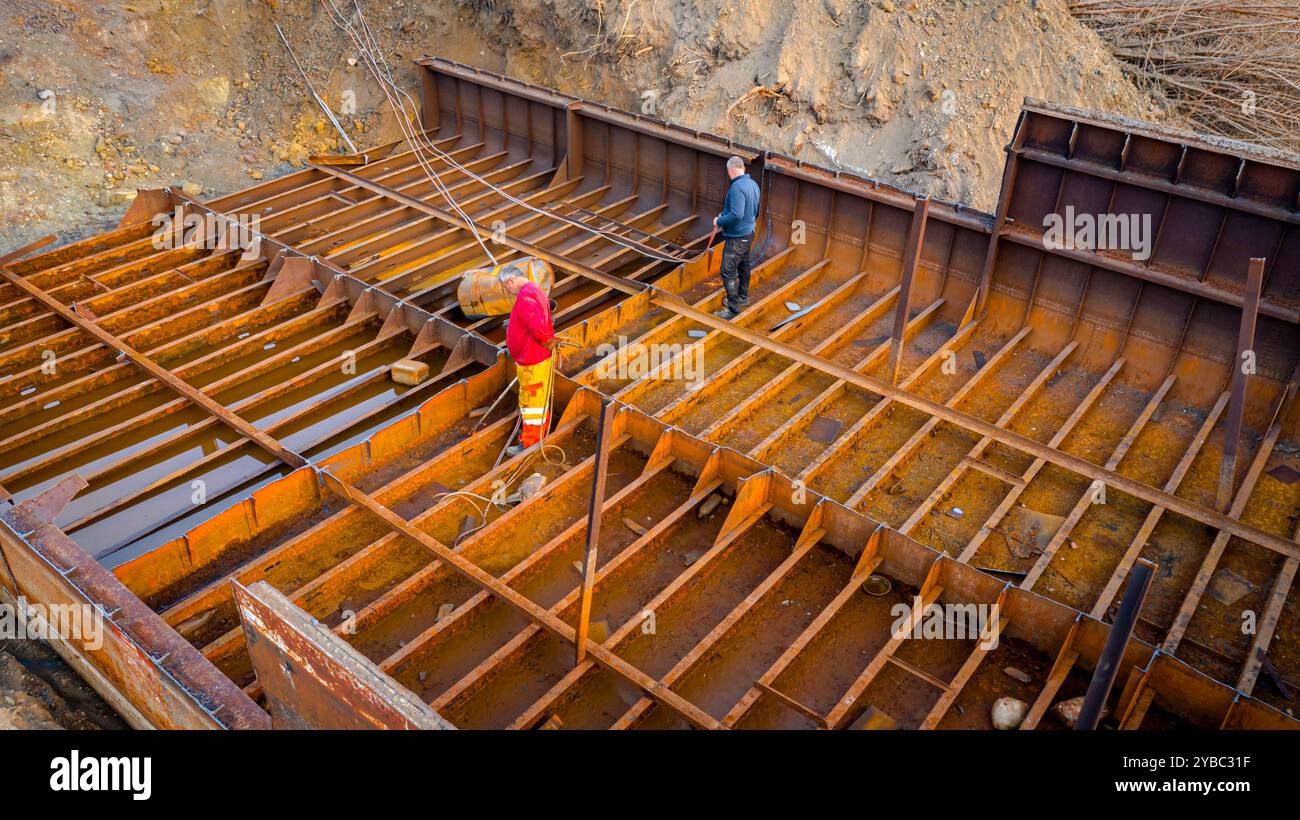 Vista dall'alto dei lavoratori durante il taglio di vecchi grandi recipienti, chiatte, smontaggio della nave in pezzi, taglio di metallo arrugginito per scarpa, utilizzando una torcia in acetilene, r Foto Stock