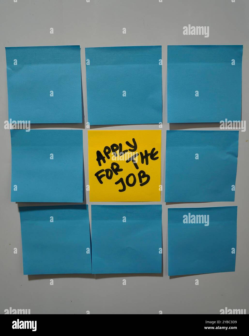 Turno di carriera. Note adesive blu che circondano una nota centrale gialla con testo applicazione lavoro. Foto Stock