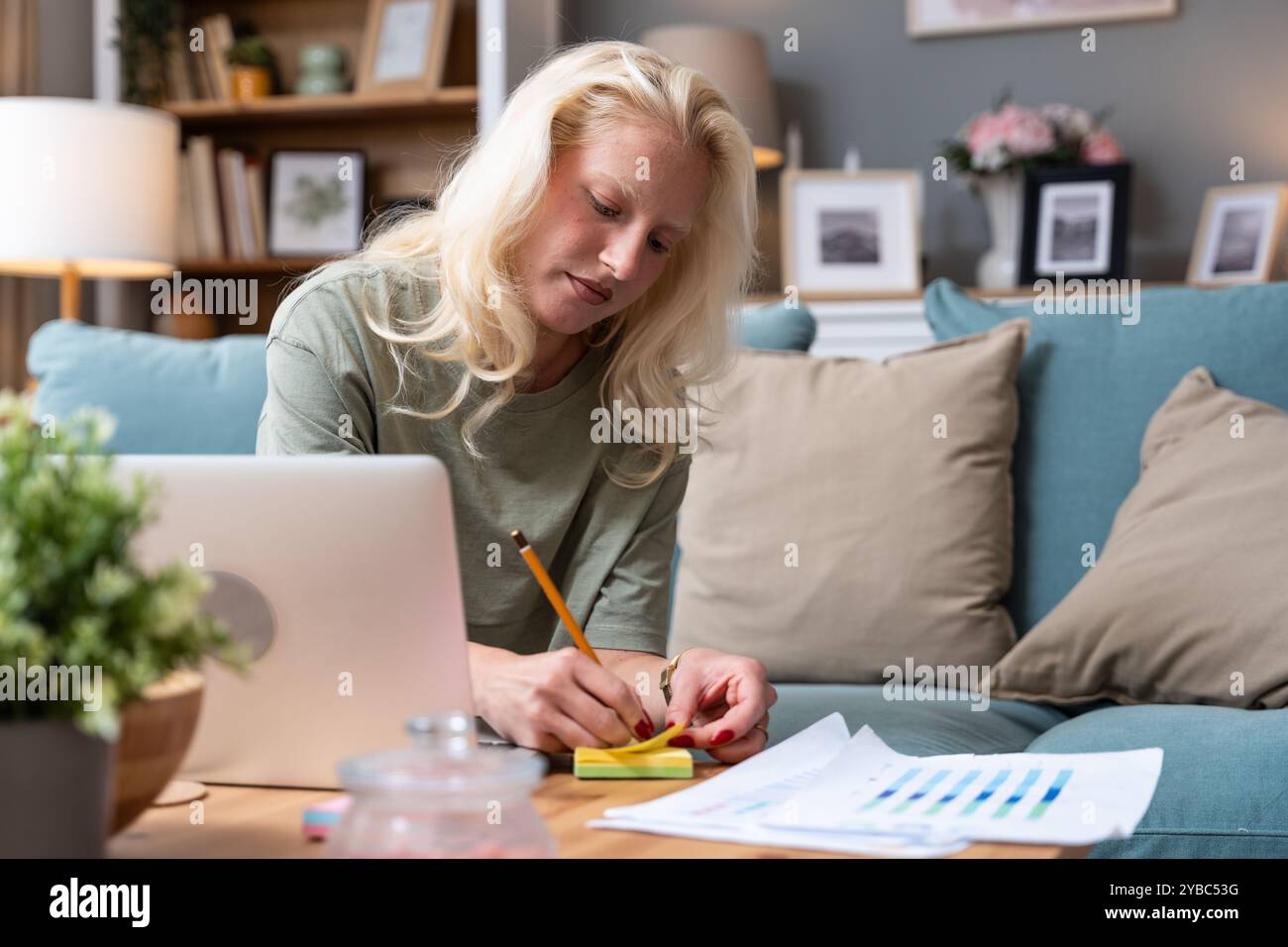 Una donna seria e concentrata che utilizza un computer portatile lavora da casa, comunica online, lavora a distanza o studia per un esame. fr. Giovane Foto Stock
