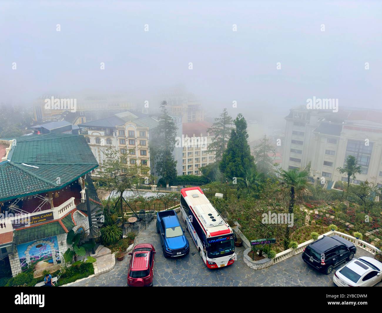 Paesaggio di montagna mescolato con nuvole ed edifici nel centro di Sapa - città sa Pa, provincia di Lao Cai, Vietnam 25 agosto 2024 Foto Stock