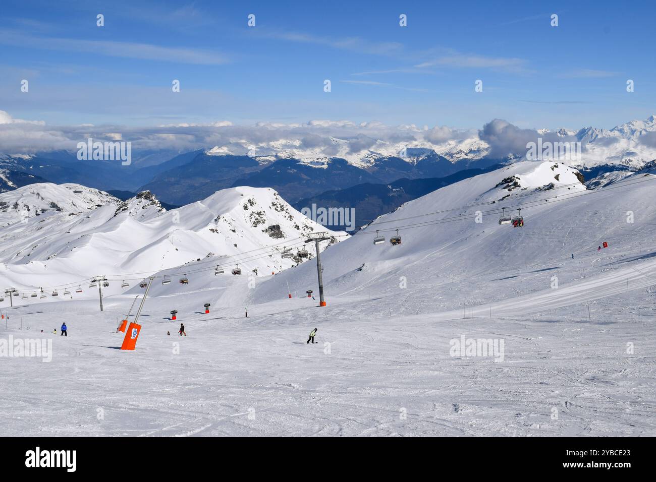 Sciatori e snowboarder che scendono sulle piste della stazione sciistica Les Menuires. Attività sportive invernali con vista sulle montagne innevate nelle tre valli. Foto Stock
