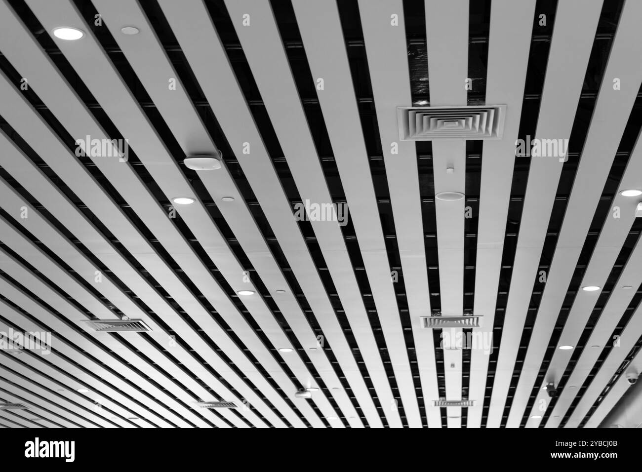 Luci e sistema di ventilazione a lunga linea sul soffitto dell'edificio industriale. Sala esposizioni. Costruzione di una fabbrica di soffitti Foto Stock