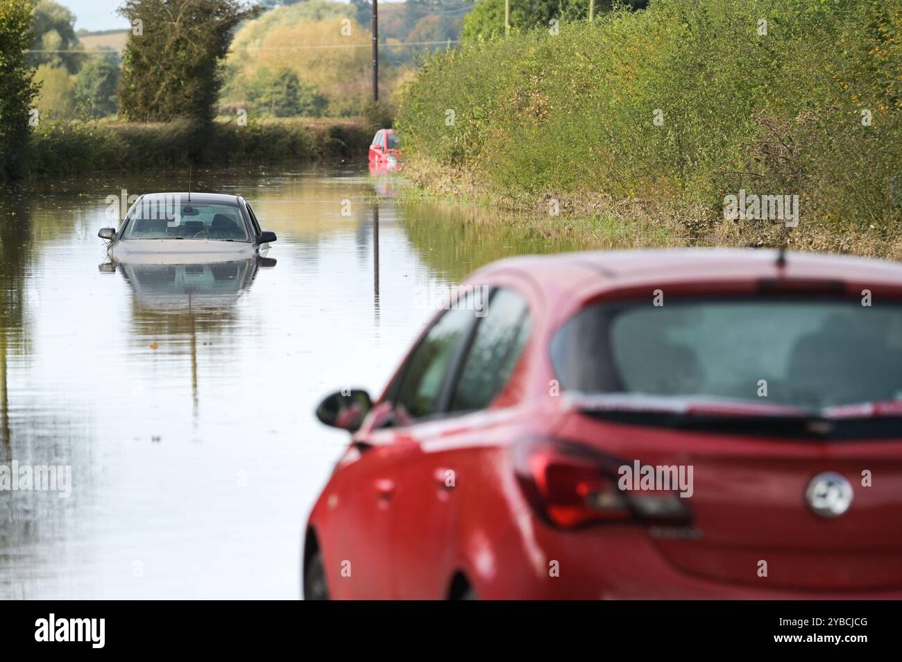 Lindridge, Worcestershire 18 ottobre 2024. Le auto si sono allagate sulla A443 a Lindridge dopo che il fiume tema ha fatto esplodere le sue rive. Tre auto furono bloccate nell'acqua alluvionale sulla strada che conduceva verso Tenbury Wells. Crediti: BNM/Alamy Live News Foto Stock