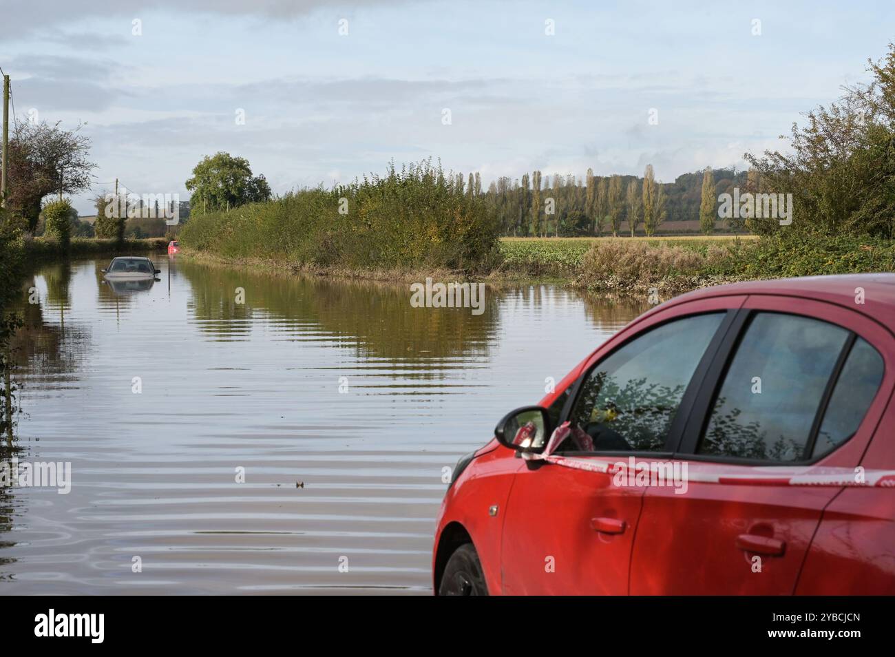 Lindridge, Worcestershire 18 ottobre 2024. Le auto si sono allagate sulla A443 a Lindridge dopo che il fiume tema ha fatto esplodere le sue rive. Tre auto furono bloccate nell'acqua alluvionale sulla strada che conduceva verso Tenbury Wells. Crediti: BNM/Alamy Live News Foto Stock