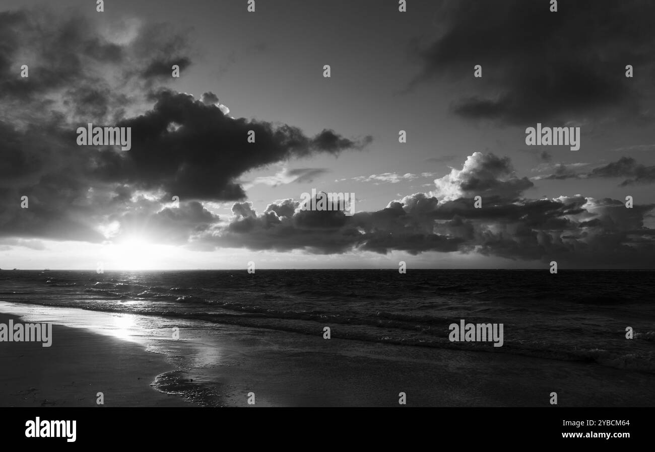 Foto in bianco e nero del paesaggio costiero con onde costiere al tramonto, oceano Atlantico. repubblica Dominicana, spiaggia di Bavaro Foto Stock