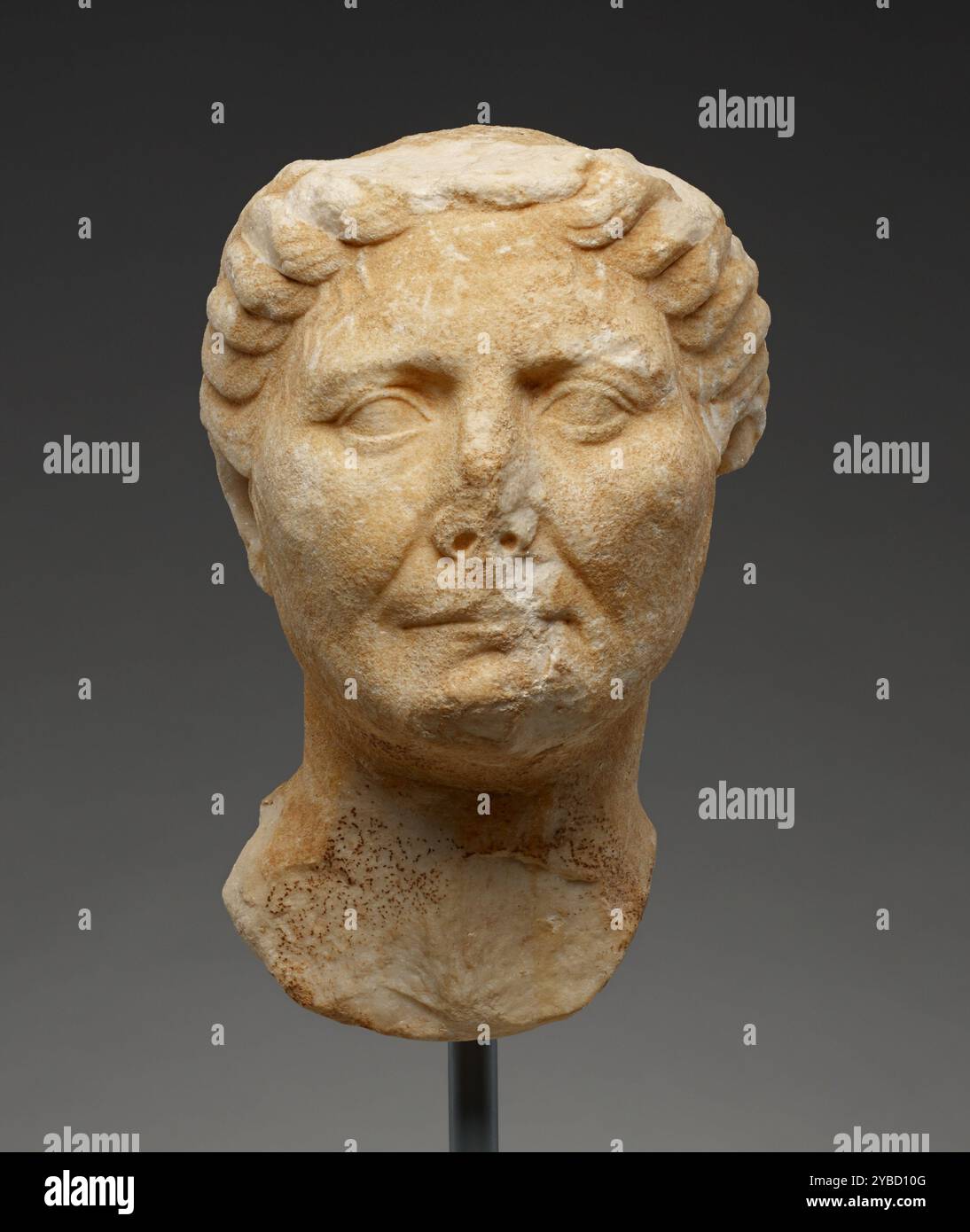 Ritratto testa di una vecchia donna, 25-1 a.C. informazioni aggiuntive: La testa è lavorata per l'inserimento in una statua. La donna ha alti zigomi, con profonde pieghe nasolabiali. I suoi capelli sono legati di nuovo a una treccia, con un nodo dietro. Ricci morbidi prima che le orecchie siano riprodotte in rilievo. Il naso è rotto e il lato anteriore e destro del viso sono stati spazzati via. Mancano anche parte dell'orecchio sinistro e la parte inferiore e laterale del nodo dei capelli. Foto Stock
