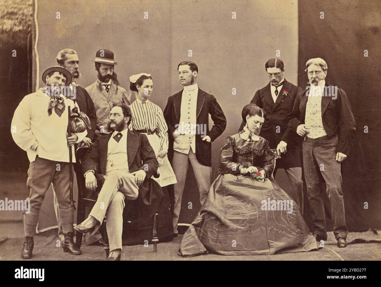 Ritratto di gruppo di uomini e donne caucasici, circa 1860-1889. Ritratto di gruppo di un certo numero di uomini e donne caucasici. Un uomo indossa un boutonni colorato a manoère sul suo bavero, mentre una delle donne tiene un fiore colorato a mano nella mano sinistra. Foto Stock