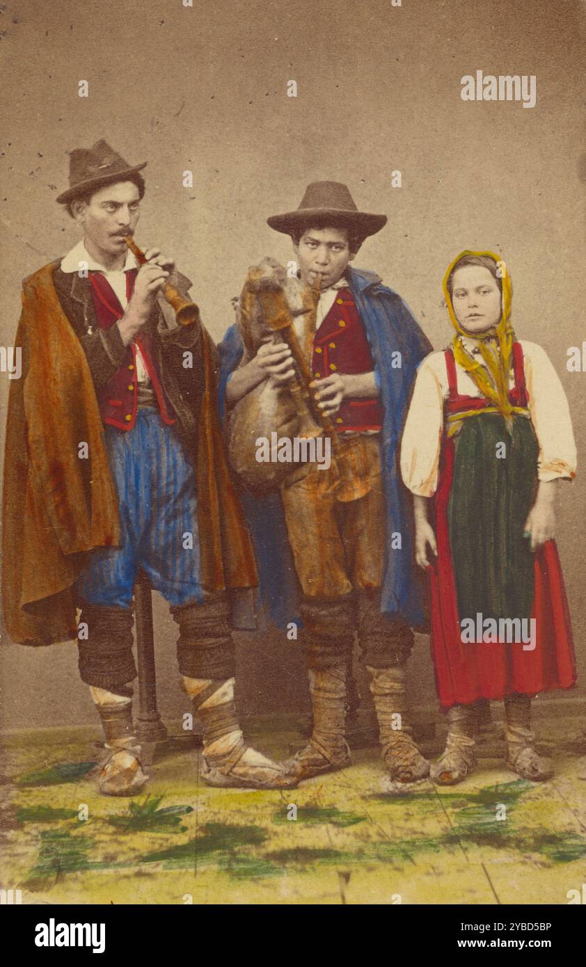 Tre contadini italiani in piedi: Due uomini che suonano strumenti a fiato, una ragazza accanto a loro, 1865-1875. Foto Stock