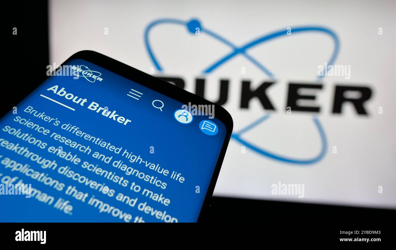 Telefono cellulare con sito web della società statunitense Bruker Corporation sullo schermo davanti al logo aziendale. Mettere a fuoco in alto a sinistra sul display del telefono. Foto Stock