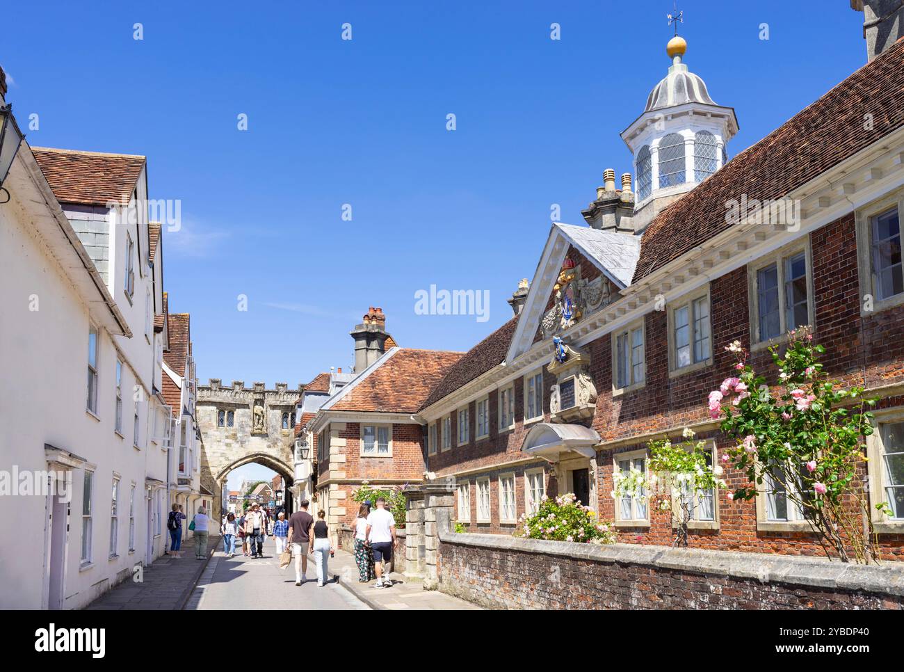 I turisti al College of Matrons Sheltered Housing registrato Almshouse e High Street Gate nella vicina Salisbury Wiltshire Inghilterra Regno Unito Europa Foto Stock