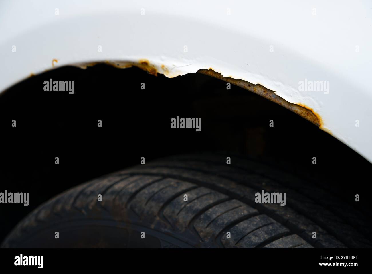 Ruggine che si forma sul passaruota di un'auto bianca, primo piano Foto Stock